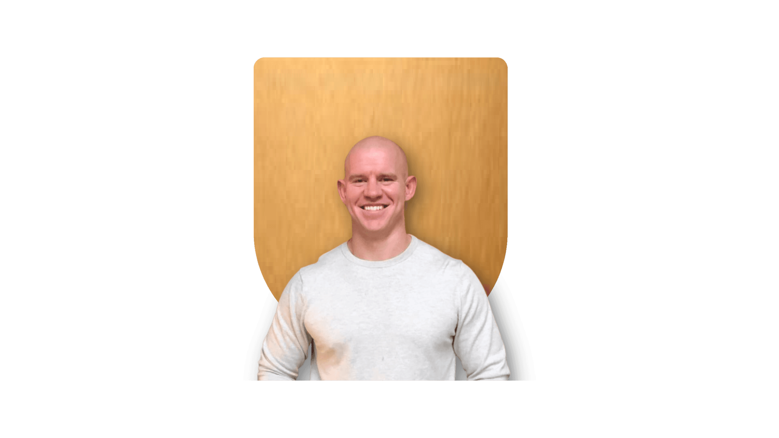 Smiling person in front of a gold shield background.